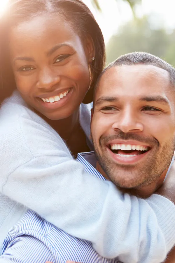 Erectile-Dysfunction-Treatment A woman riding on a man's back, both smiling due to help with erectile dysfunction from David Garcia, D.O. in Nashville Metro.