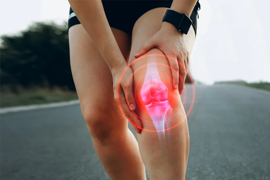 Exosomes-for-Knee-Pain-Clinic A woman on a run holds her inflamed knee. Get exosome therapy for knee pain from David Garcia, D.O. in Nashville Metro.