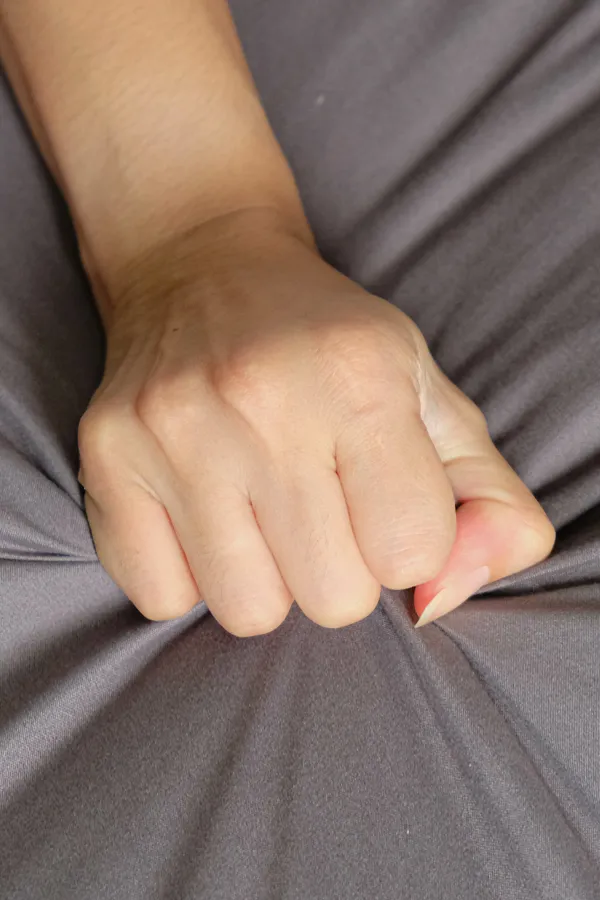 Female-Sexual-Dysfunction-Treatment Close-up of a woman's hand grabbing a sheet, indicating sexual pleasure. Get female sexual dysfunction treatment from David Garcia, D.O. in Nashville Metro.