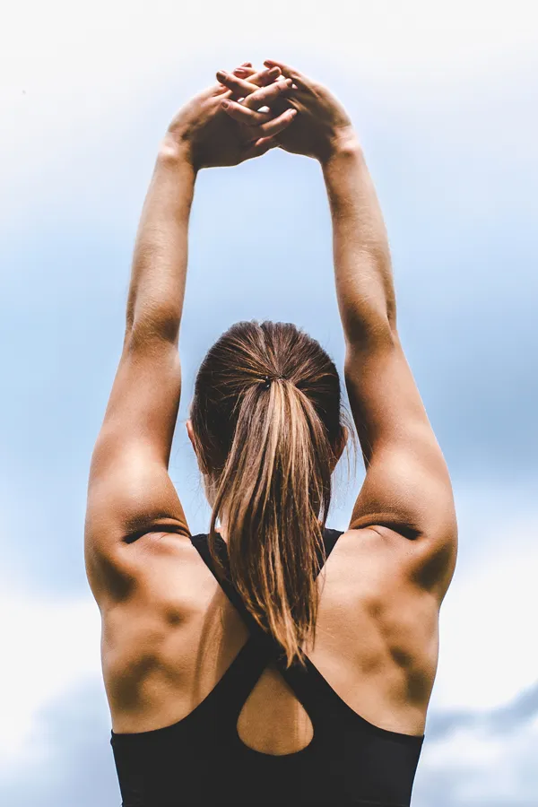 GLP-1-Weight-Loss-Injections-Treatment A toned woman seen from behind stretching her arms into the air. Get GLP-1 Weight Loss Injections from David Garcia, D.O. in Nashville Metro.