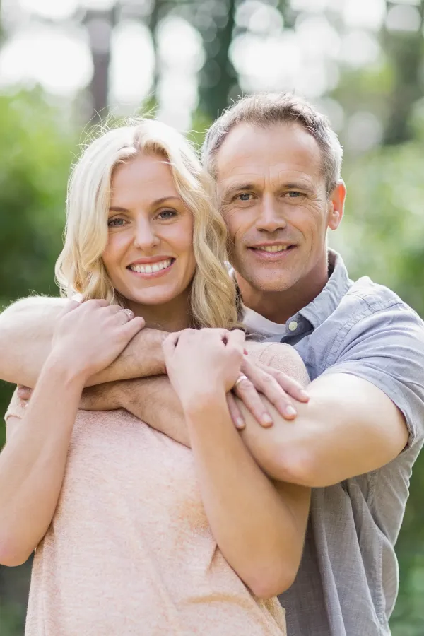 HGH-Hormone-Treatment A middle-aged couple embrace outdoors on a sunny day. Get HGH hormone therapy from David Garcia, D.O. in Nashville Metro.