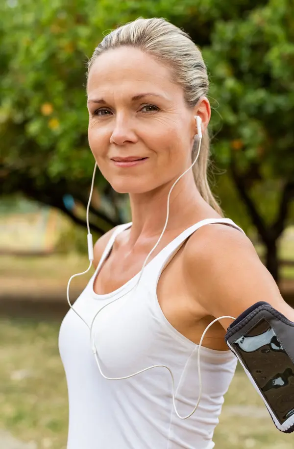 Insulin-Resistance-Treaatment A fit middle aged woman wearing earphones and a tank top smiles after a run. Get insulin resistance treatment from David Garcia, D.O. in Nashville Metro.