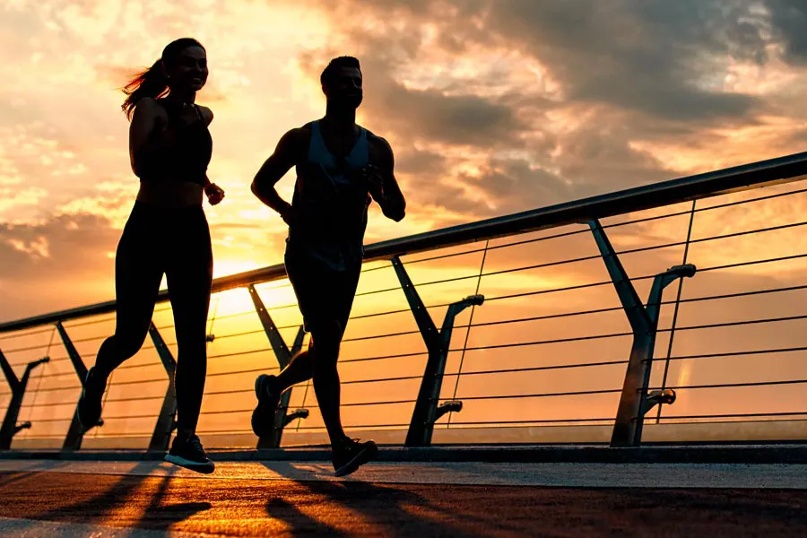 Performance-Enhancing-Peptides-Doctor A couple jogging on a bridge at sunrise, representing performance enhancing peptide therapy from David Garcia, D.O. in Nashville Metro.