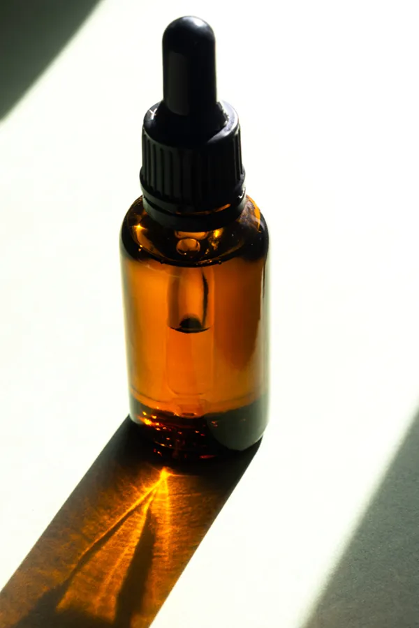 Performance-Enhancing-Peptides-Treatment A brown dropper bottle on a table lit by sunlight, representing performance enhancing peptide treatment from David Garcia, D.O. in Nashville Metro.