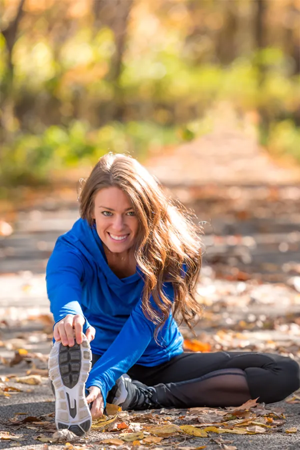 Sermorelin-Treatment A healthy woman in blue sweats stretches on a trail before a run. Get Sermorelin peptide therapy from David Garcia, D.O. in Nashville Metro.