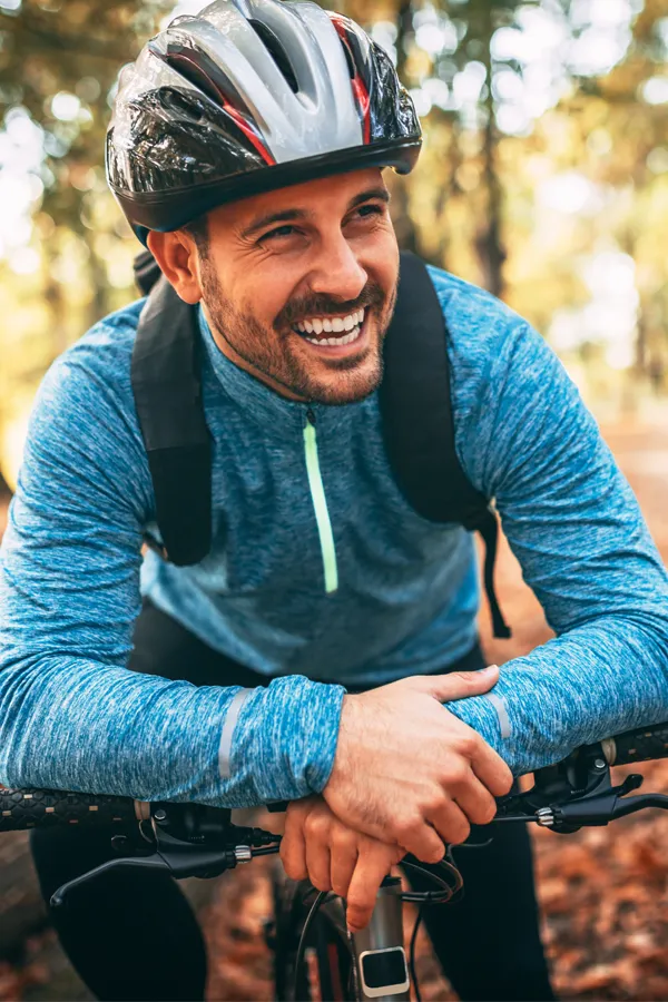 Testosterone-Low-T-Solutions-Treatment A middle-aged man on a trail in cycling clothes is smiling and leaning on his bike's handlebars. Get testosterone for Low T from David Garcia, D.O. in Nashville Metro.
